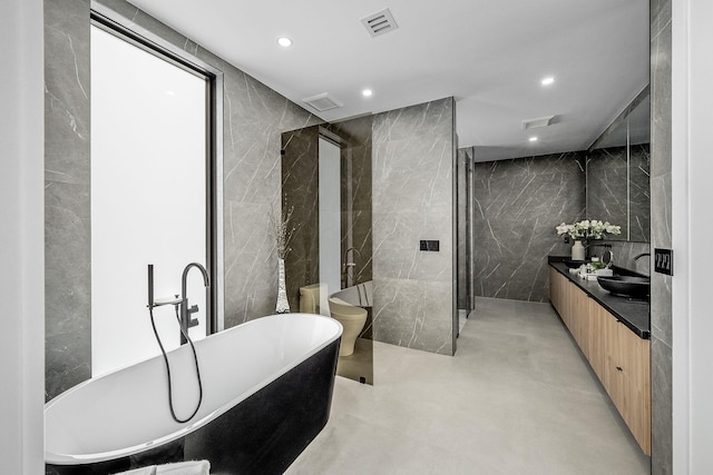 bathroom with vanity, tile walls, concrete floors, and shower with separate bathtub