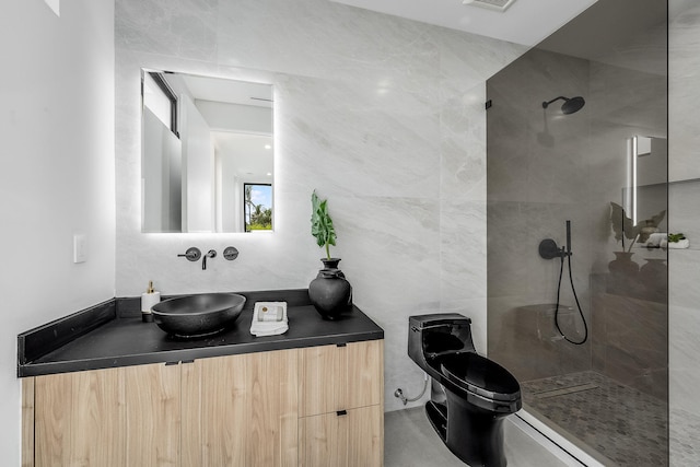 bathroom with tile walls, toilet, a tile shower, and vanity