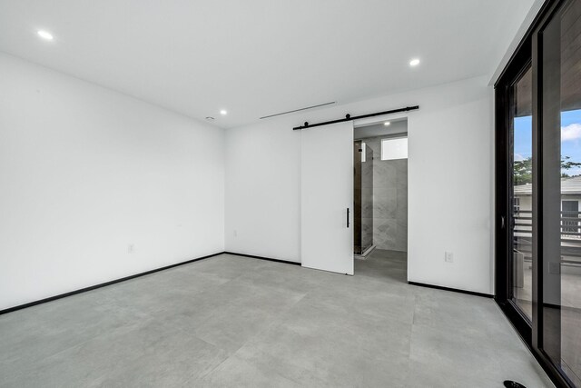 unfurnished room featuring a barn door