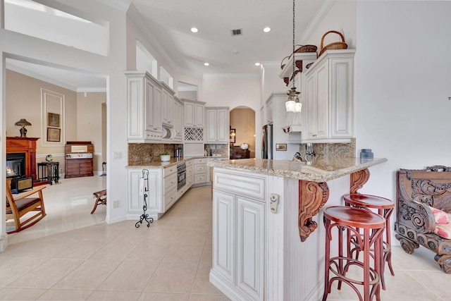 kitchen with decorative backsplash, ornamental molding, light stone counters, kitchen peninsula, and light tile patterned flooring