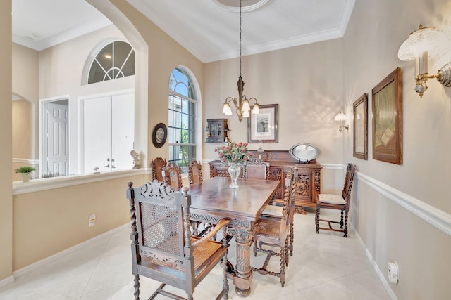 dining area with light tile patterned flooring, a chandelier, and ornamental molding