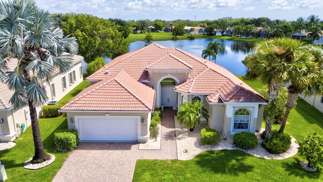 view of front of property featuring a water view, a garage, and a front lawn