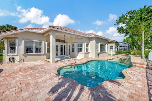 view of pool with ceiling fan, pool water feature, french doors, and a patio area