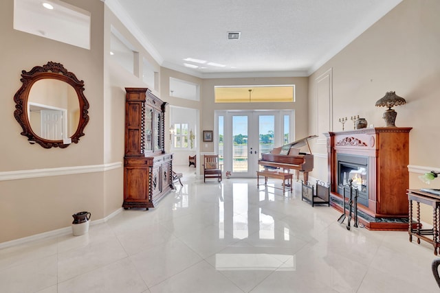 interior space featuring a towering ceiling, ornamental molding, french doors, and a textured ceiling