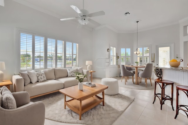 tiled living room featuring ceiling fan, crown molding, and a towering ceiling