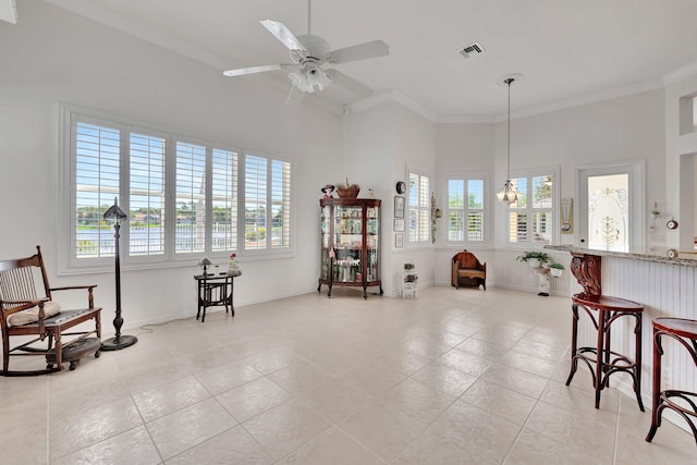 sitting room featuring ceiling fan with notable chandelier, light tile patterned flooring, and ornamental molding