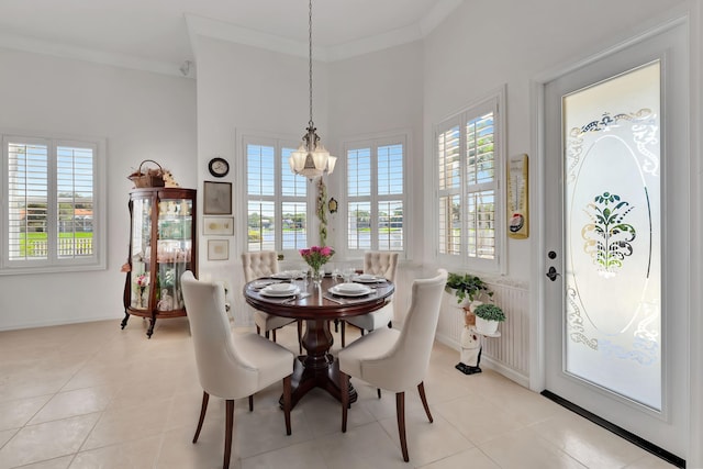 dining space featuring light tile patterned flooring, a notable chandelier, and ornamental molding