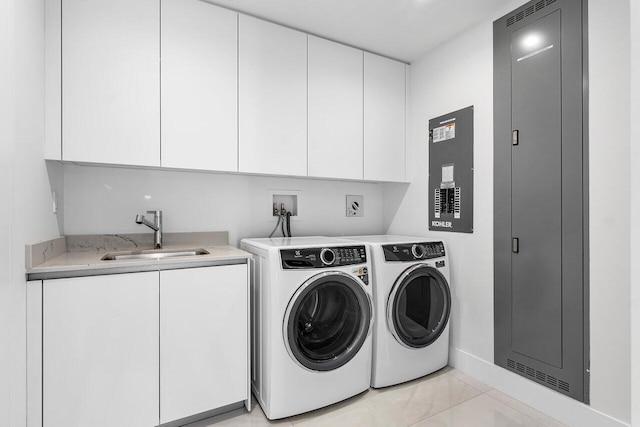 laundry area with separate washer and dryer, a sink, and cabinet space