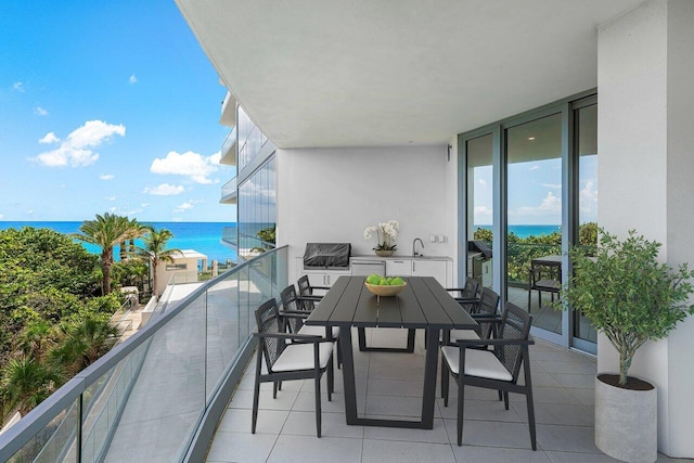 balcony featuring a water view and a sink