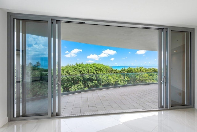 doorway featuring a water view and light tile patterned floors