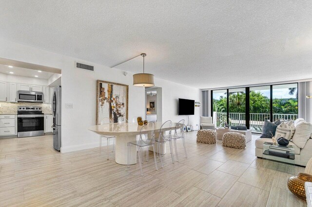 living room featuring a textured ceiling and a wall of windows