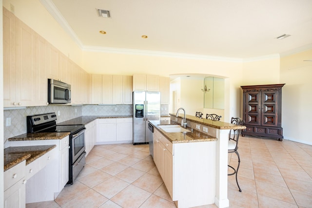 kitchen with a kitchen bar, visible vents, a sink, stainless steel appliances, and light tile patterned flooring