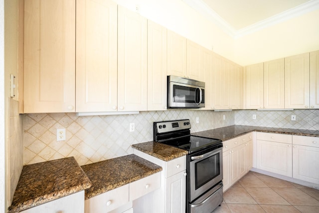 kitchen featuring ornamental molding, dark stone countertops, tasteful backsplash, appliances with stainless steel finishes, and light tile patterned floors