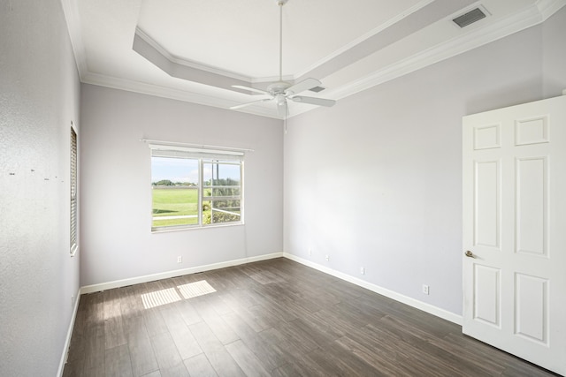 unfurnished room featuring visible vents, dark wood-type flooring, ornamental molding, a tray ceiling, and baseboards