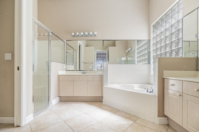 full bathroom featuring vanity, a bath, a shower stall, and tile patterned flooring