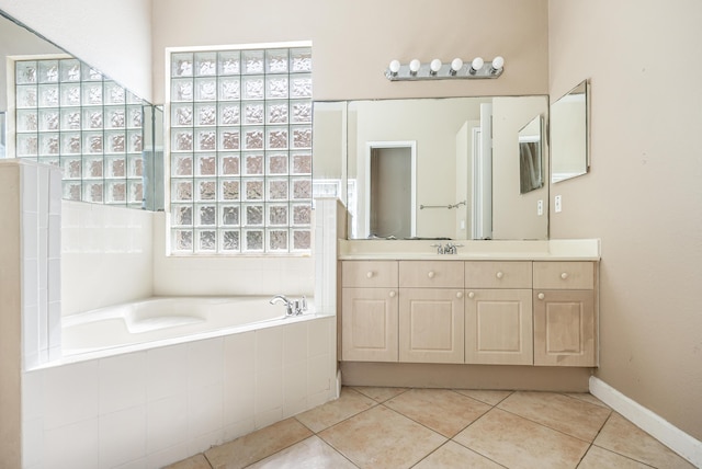 bathroom with vanity, tile patterned floors, a bath, and baseboards