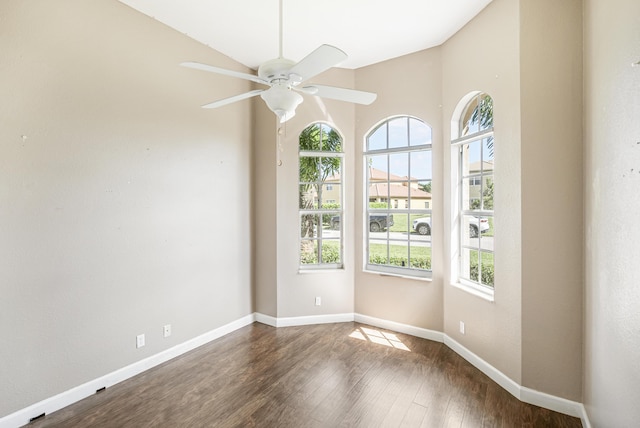 empty room featuring wood finished floors, baseboards, a wealth of natural light, and ceiling fan