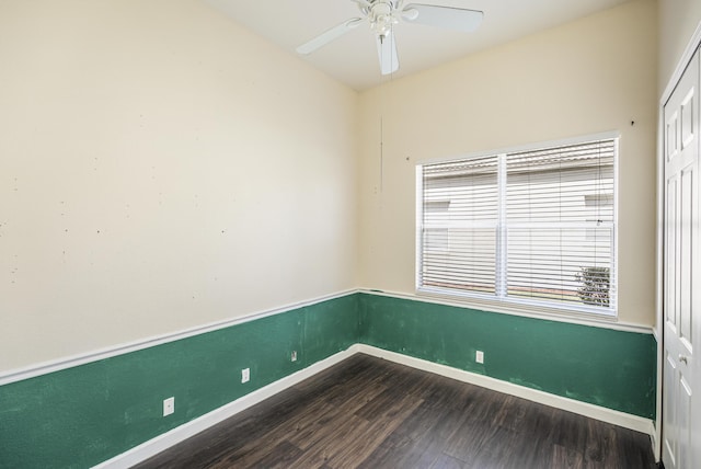 unfurnished room featuring dark wood finished floors, baseboards, and ceiling fan