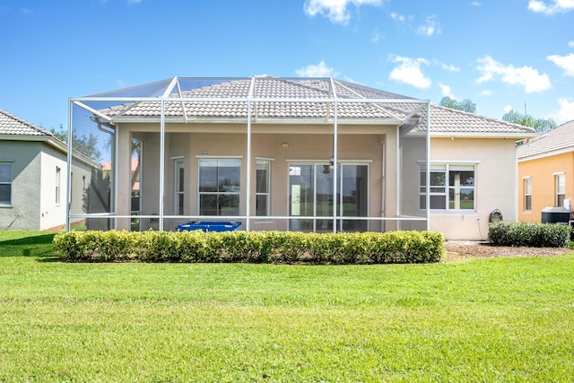 back of house featuring stucco siding, a lawn, glass enclosure, and a tile roof