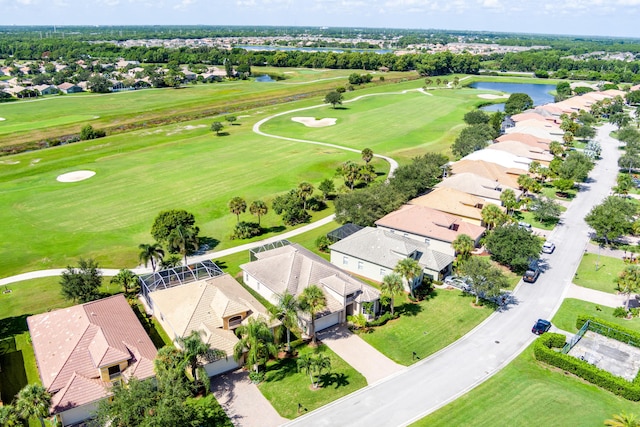 drone / aerial view featuring view of golf course, a residential view, and a water view