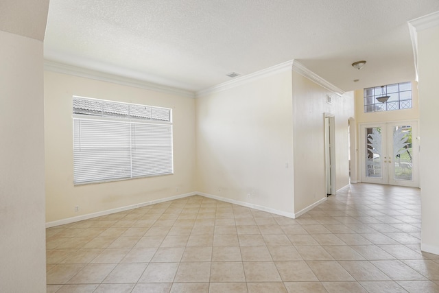 spare room featuring light tile patterned floors, french doors, a textured ceiling, and ornamental molding