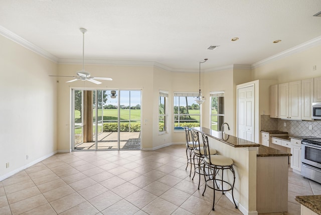 kitchen with tasteful backsplash, visible vents, a kitchen bar, ornamental molding, and stainless steel appliances