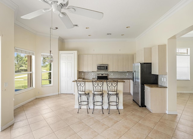 kitchen featuring a kitchen island, crown molding, light tile patterned floors, decorative backsplash, and stainless steel appliances