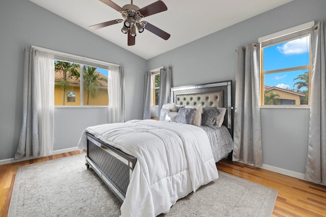 bedroom with ceiling fan, light hardwood / wood-style flooring, and lofted ceiling