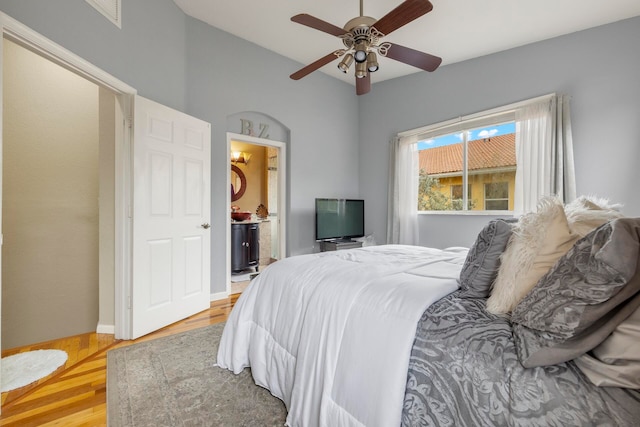 bedroom with ceiling fan, connected bathroom, and light wood-type flooring