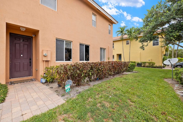 doorway to property with a yard