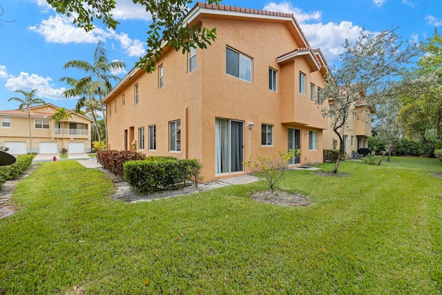 rear view of property with a yard and a garage