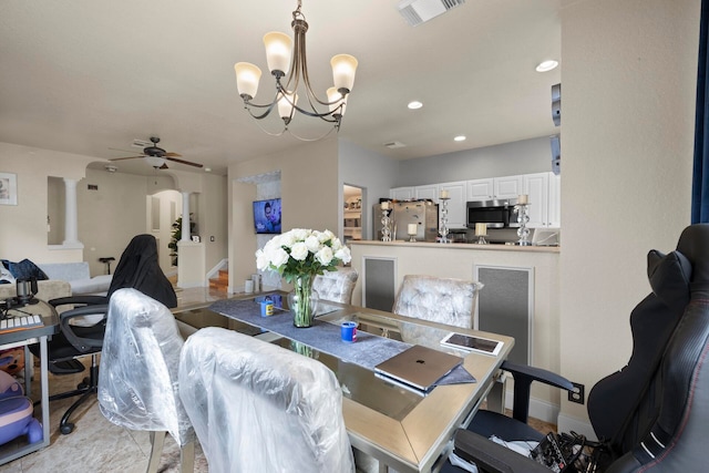 dining area with light tile patterned floors, ceiling fan with notable chandelier, and ornate columns