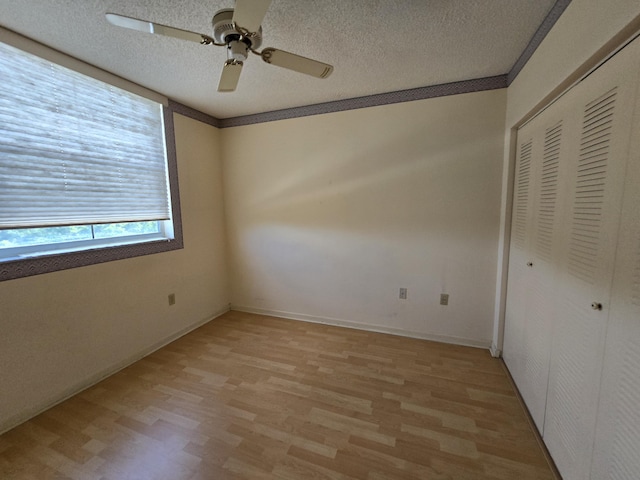 unfurnished bedroom with light wood-style flooring, a closet, ceiling fan, and a textured ceiling