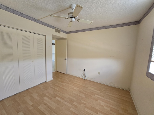 unfurnished bedroom with a textured ceiling, visible vents, a closet, and light wood-style flooring