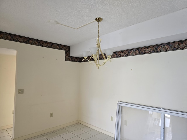 unfurnished room featuring a chandelier, light tile patterned flooring, and a textured ceiling