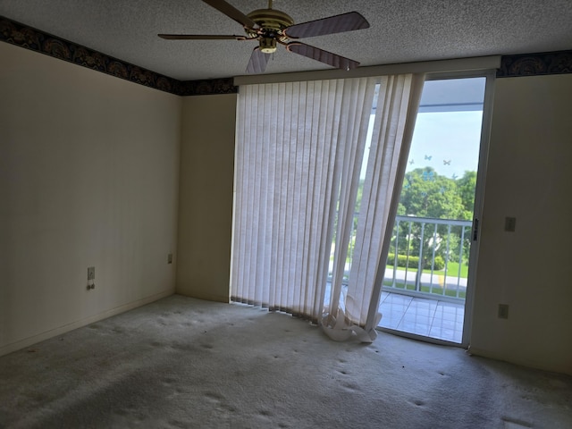 carpeted empty room with a textured ceiling and ceiling fan