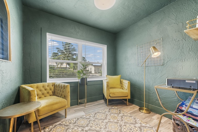 sitting room featuring a textured ceiling and light wood-type flooring