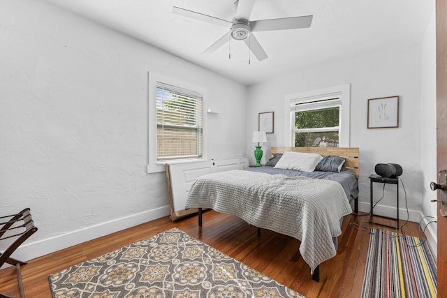 bedroom featuring multiple windows, wood-type flooring, and ceiling fan