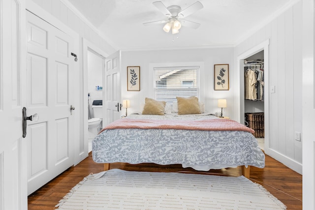 bedroom featuring crown molding, hardwood / wood-style flooring, a walk in closet, and a closet