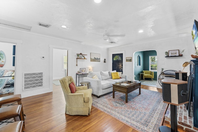 living room with hardwood / wood-style flooring, a textured ceiling, and ceiling fan