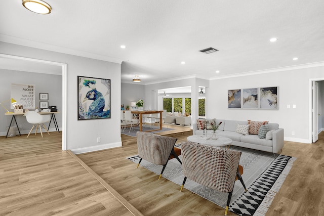 living room with light hardwood / wood-style floors, crown molding, and ceiling fan