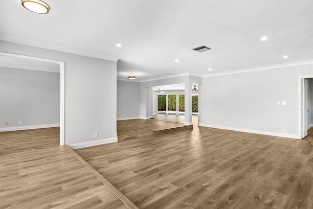 unfurnished living room with crown molding and hardwood / wood-style flooring