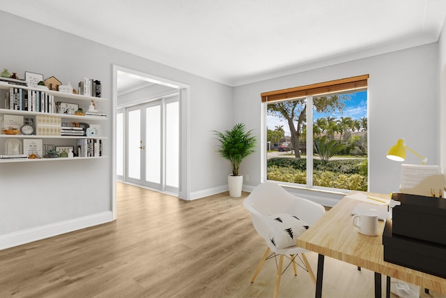 home office with light hardwood / wood-style floors and crown molding