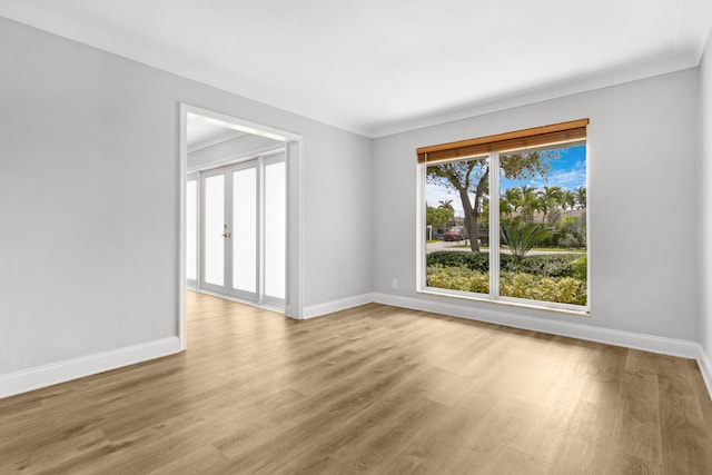 spare room with light hardwood / wood-style floors and crown molding