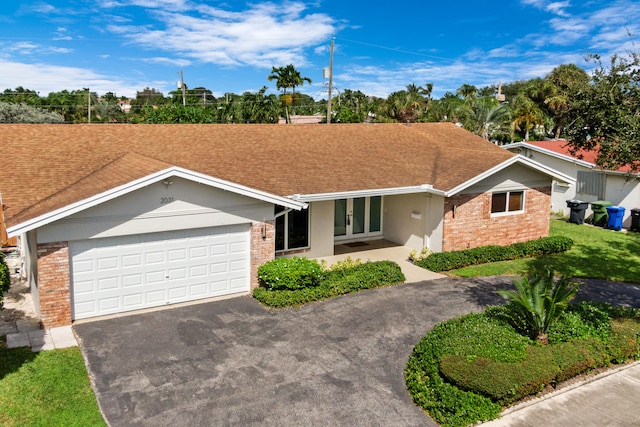 ranch-style home featuring a front lawn and a garage