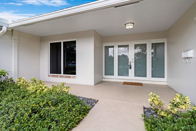 entrance to property featuring french doors and a patio area