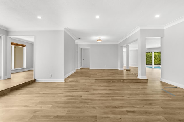 empty room with ornamental molding and light hardwood / wood-style flooring