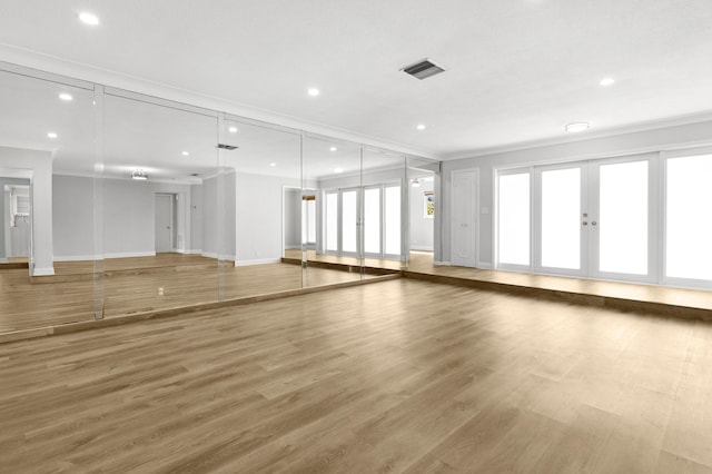 unfurnished living room featuring ornamental molding and hardwood / wood-style floors