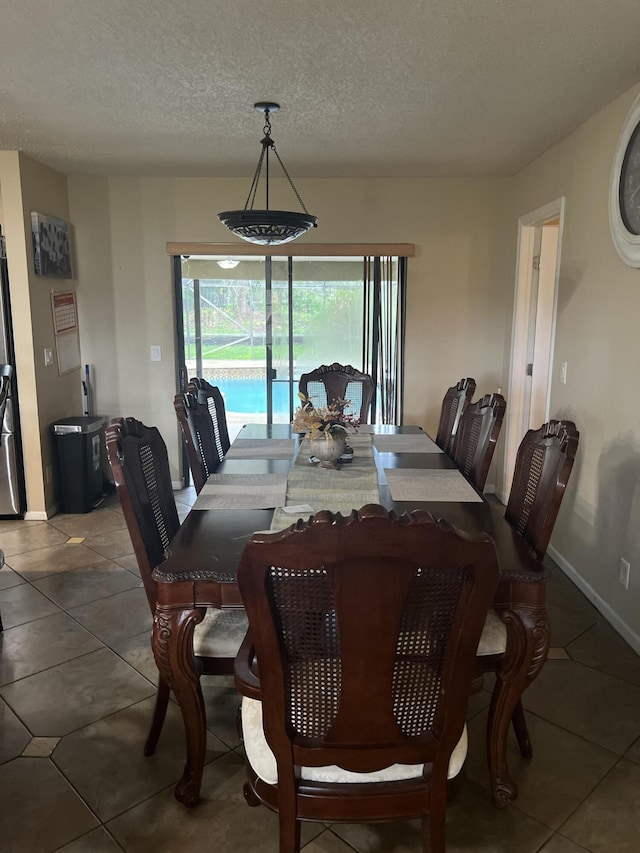 dining space featuring a textured ceiling and tile patterned floors