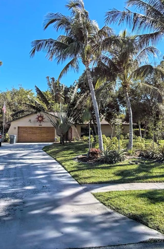 view of front of house featuring a garage and a front lawn